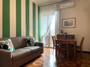 ein Wohnzimmer mit einem Sofa, einem Tisch und Stühlen in der Unterkunft Apartment Station Sesto - Affitti Brevi Italia in Sesto San Giovanni