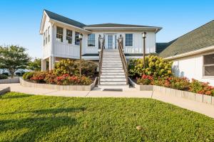 a white house with stairs and flowers in a yard at Mallard Lakes -- 38287 Cardinal #139 in Selbyville