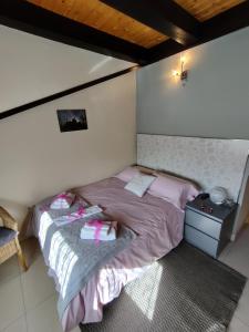 a small bedroom with a bed with pink sheets at Las Cigüeñas de San Cristóbal in San Cristóbal de Segovia