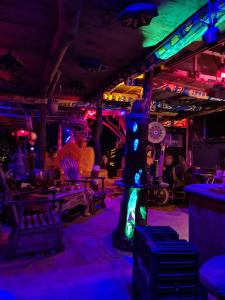 un bar con luci viola e verdi in una stanza di Humbhaha jungle yala nature eco resort a Kataragama