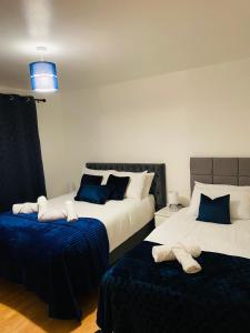 Cheerful home near City Centre,Station& RaceCourse في دونكاستير: غرفة نوم بسريرين باللونين الأزرق والأبيض