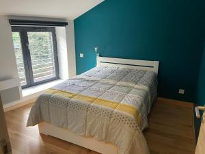1 dormitorio con 1 cama con pared azul en Gîtes Aubergine et Poivron en Toulaud