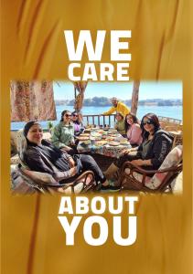 um cartaz de um grupo de pessoas sentadas em torno de uma mesa em Opal privat nubian hotel em Aswan