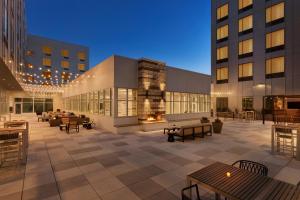 un patio con mesas y bancos y un edificio en Staybridge Suites Rochester - Mayo Clinic Area, an IHG Hotel, en Rochester