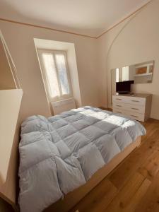 a bedroom with a bed and a dresser and a window at La casa di Grace in Savona