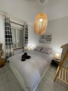 a bedroom with a large white bed with a chandelier at Le Bohème - Centre Ville, Netflix et WIFI, parking, idéal familles, couples et voyages d'affaire in Niort