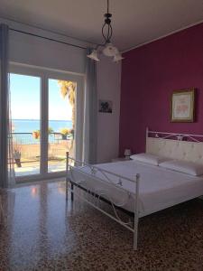 a bedroom with a bed and a balcony with the ocean at Oltremare Salerno Apartment in Salerno
