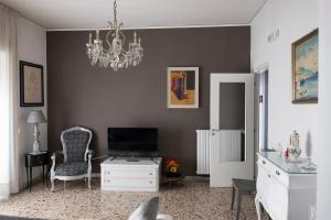 a living room with a television and a chandelier at Oltremare Salerno Apartment in Salerno