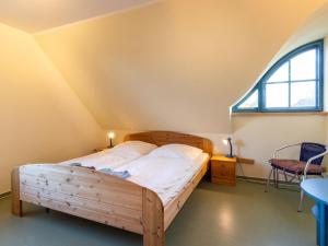 a bedroom with a wooden bed and a window at Semi-detached house in the port village of Vieregge on the island of Rügen in Vieregge