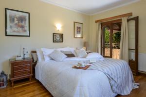 a bedroom with a white bed with a tray on it at Vivian's Residence Endless View in Svoronata
