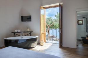 a bedroom with a bath tub and a sliding glass door at Iancura - B&B di design a Salina in Santa Marina Salina