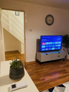 a living room with a tv and a table at Cheerful home near City Centre,Station& RaceCourse in Doncaster