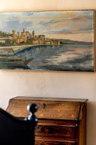 Un dipinto appeso a un muro accanto a un comò di Casa Novella a Novello
