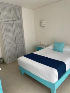 um quarto com uma cama azul e branca num quarto em Luna Creciente em Santa Cruz, Huatulco