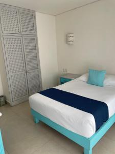 Un dormitorio con una cama azul y blanca en una habitación en Luna Creciente en Santa Cruz - Huatulco