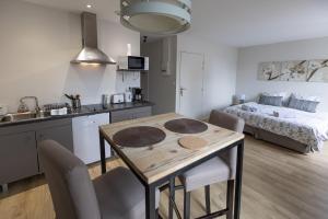 a kitchen and living room with a table and a bed at Les Agîtés in Bain-de-Bretagne
