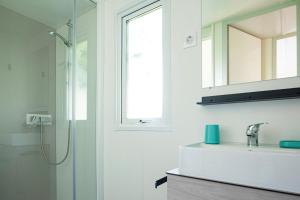 bagno con doccia, lavandino e specchio di Mobile Home OuiReves 221 facing the Mediterranean a Lattes
