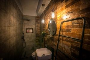 a bathroom with a sink and a toilet and a brick wall at The Old Market House in Tríkala +17 photos