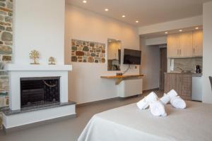 Aelia Mount Suites في زاغورا: غرفة نوم بها موقد وسرير به وسائد بيضاء