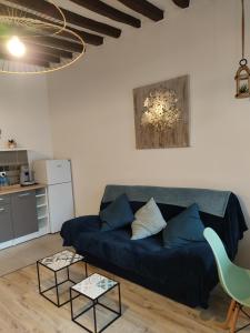 a living room with a blue couch and two tables at Apt lumineux in Gonesse