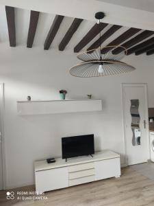 a living room with a tv on a white wall at Apt lumineux in Gonesse