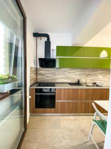 uma cozinha com armários verdes e um fogão em VR2 Central Apartment em Bucareste