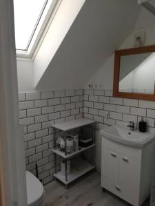 a white bathroom with a sink and a mirror at Udvari-ház in Balatonudvari
