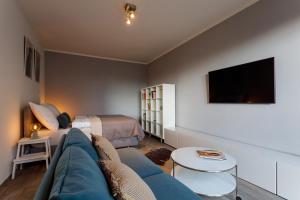 a living room with a couch and a bed and a television at Golden Apartments Rezidence Nová Karolina II. in Ostrava