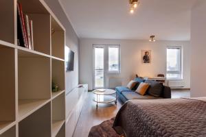 1 dormitorio con 1 cama y 1 sofá en Golden Apartments Rezidence Nová Karolina II., en Ostrava