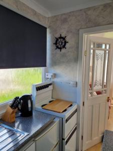 een keuken met een fornuis en een aanrecht bij Charming 2 Bedroom Holiday Chalet in Withernsea