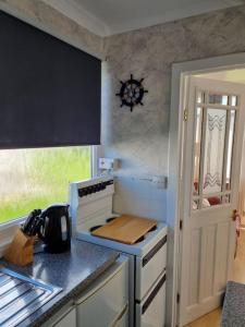 a kitchen with a stove and a counter top at Charming 2 Bedroom Holiday Chalet in Withernsea