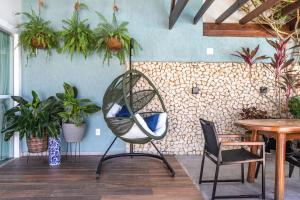 une chaise dans une pièce avec une table et des plantes dans l'établissement CASA CAJU, à Aracaju