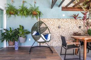 a chair in a room with a table and plants at CASA CAJU in Aracaju