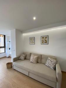 ein weißes Wohnzimmer mit einem Sofa in einem Zimmer in der Unterkunft El Apartamento de Cristian 3 in Benidorm