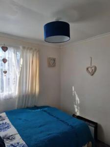 una camera con un letto blu e una finestra di Charming 2 Bedroom Holiday Chalet a Withernsea