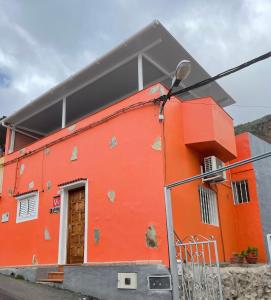 ein orangefarbenes Gebäude mit einer Tür und einer Straßenbeleuchtung in der Unterkunft Chalet Rutas de Valsequillo in Valsequillo de Gran Canaria