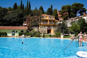 a woman is playing in a swimming pool at Vila Školka studio in Portorož