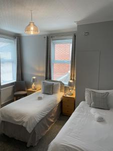 - 2 lits dans une chambre avec 2 fenêtres dans l'établissement Rivendell Guest House, à Southampton