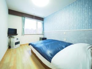 מיטה או מיטות בחדר ב-Petit Hotel Gracey Tomamu