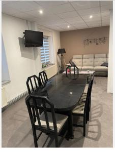 a black table and chairs in a room with a couch at Appartement saisonnier in Bussang