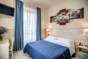 una camera con letto blu e finestra di Hotel Ottaviano Augusto a Roma