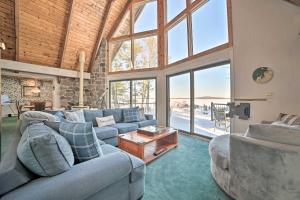 a large living room with couches and a large window at Dreamy Lake Skegemog Retreat Boat, Ski and Sip! in Williamsburg
