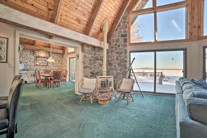 a living room with a fireplace and a table and chairs at Dreamy Lake Skegemog Retreat Boat, Ski and Sip! in Williamsburg