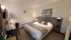 une chambre d'hôtel avec un lit éclairé dans l'établissement Hôtel Le Valois, Cognac Centre, à Cognac