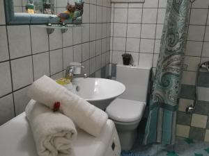 a bathroom with a toilet and a sink with towels at Cozy Home (close to the beach) in Nea Kydonia