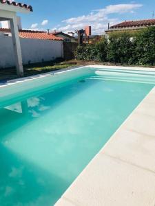 a large pool of blue water in a yard at Casa en Villa Carlos Paz con Pileta , Quincho y Jardín a Pasos del Centro in Villa Carlos Paz