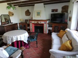 a living room with a table and a fireplace at El Alojamiento Rural de Peter in Aracena