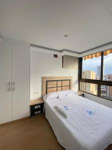 1 dormitorio con cama grande y ventana grande en El Apartamento de Cristian 3 en Benidorm