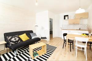 a living room with a black couch and a table at Vlnka Apartments in Piešťany