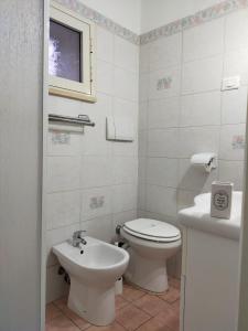 a white bathroom with a toilet and a sink at La Tegola in Tivoli +19 photos